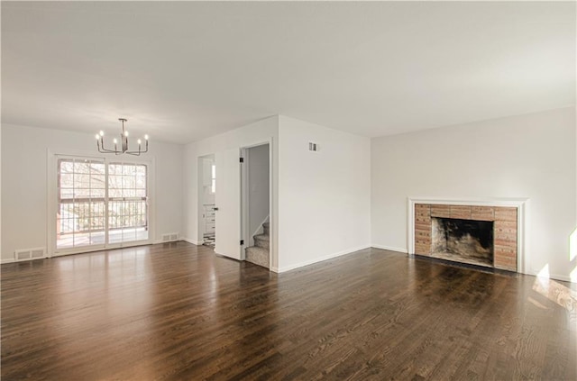 unfurnished living room with a chandelier, dark wood-style floors, stairway, and visible vents