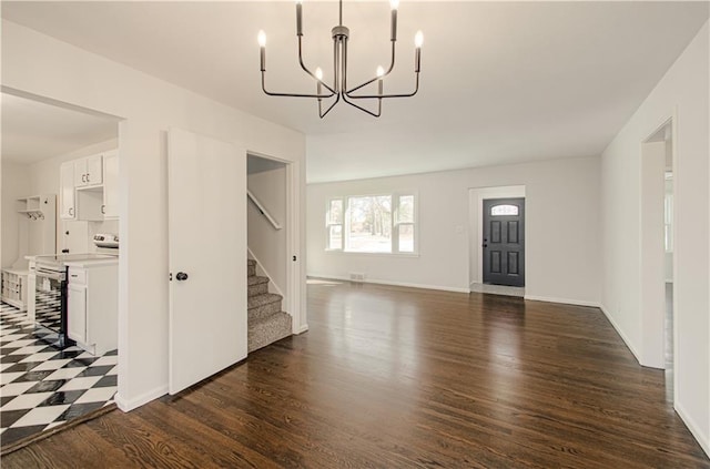 interior space with a chandelier, dark wood-style floors, stairs, and baseboards