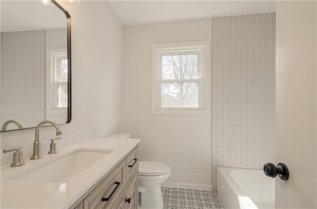 bathroom with vanity, toilet, and baseboards