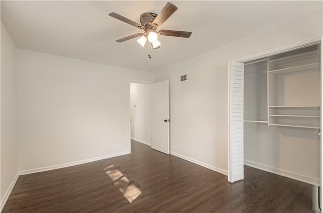 unfurnished bedroom with visible vents, baseboards, dark wood-type flooring, and a closet