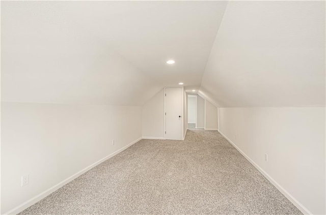 additional living space featuring recessed lighting, light colored carpet, baseboards, and vaulted ceiling