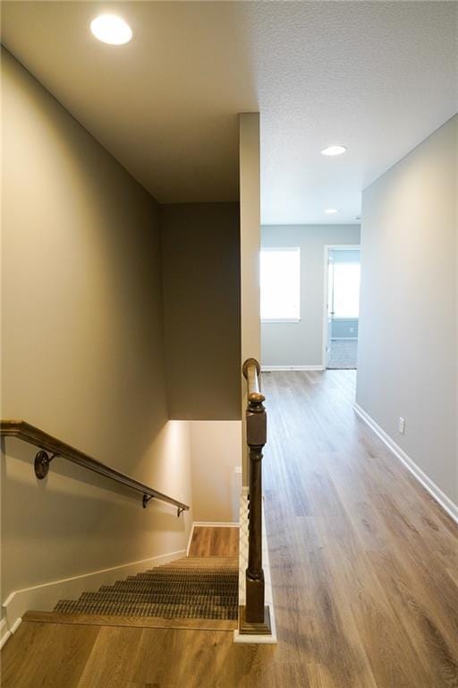 staircase featuring recessed lighting, wood finished floors, and baseboards