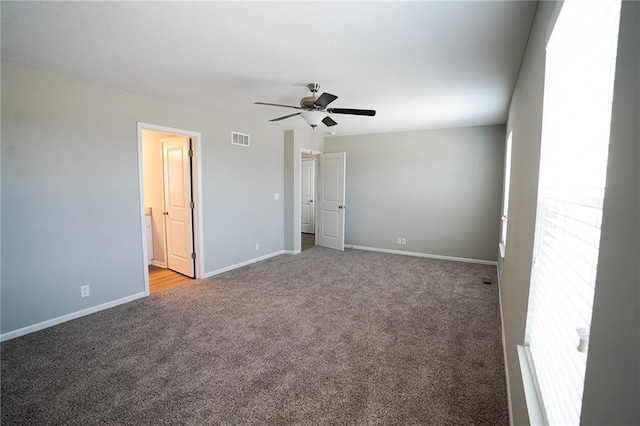 empty room with visible vents, baseboards, carpet flooring, and a ceiling fan