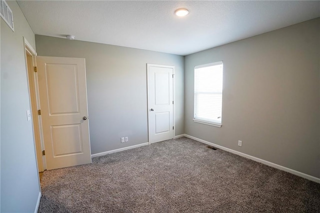 unfurnished bedroom with visible vents, baseboards, and carpet floors