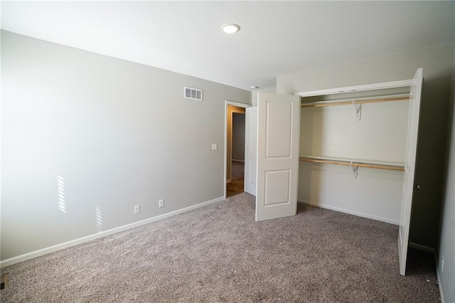 unfurnished bedroom featuring visible vents, carpet floors, baseboards, and a closet