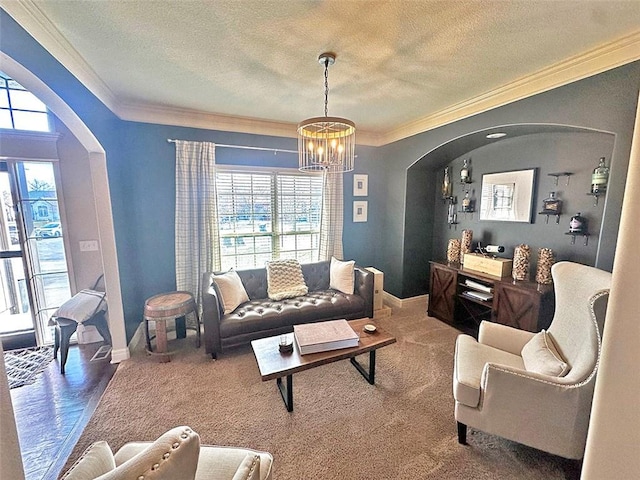 living area with a textured ceiling, arched walkways, carpet floors, and ornamental molding