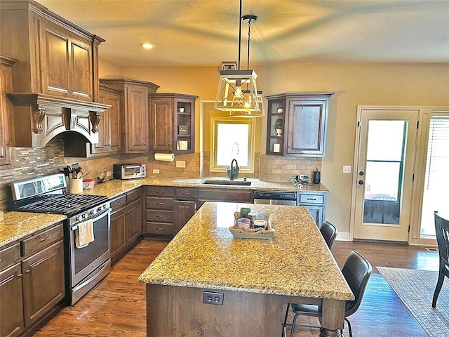 kitchen with a sink, decorative backsplash, appliances with stainless steel finishes, and dark wood-style flooring