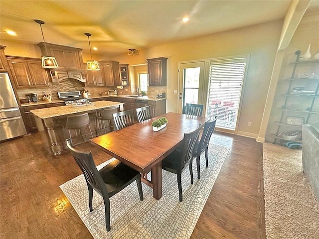 dining area featuring baseboards and dark wood-type flooring