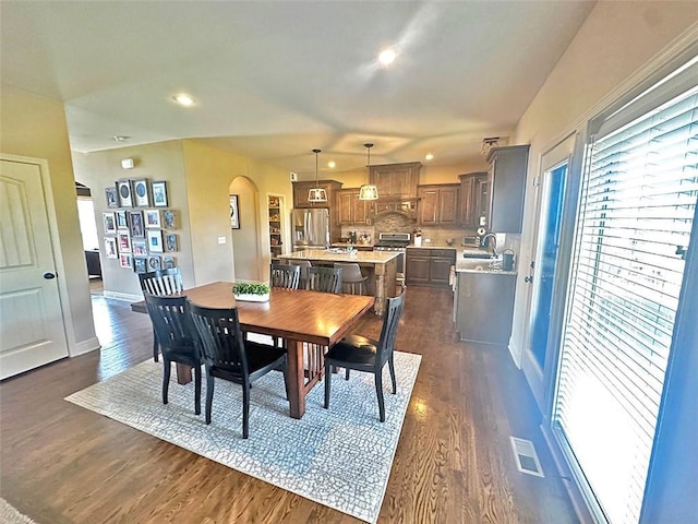 dining room featuring visible vents, baseboards, recessed lighting, arched walkways, and dark wood-style flooring