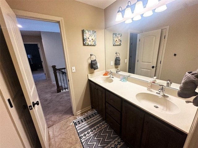 full bath featuring double vanity, tile patterned floors, baseboards, and a sink