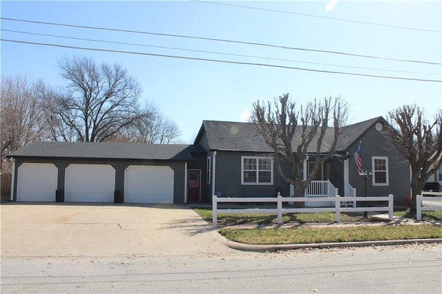 ranch-style house with concrete driveway, a garage, and a fenced front yard