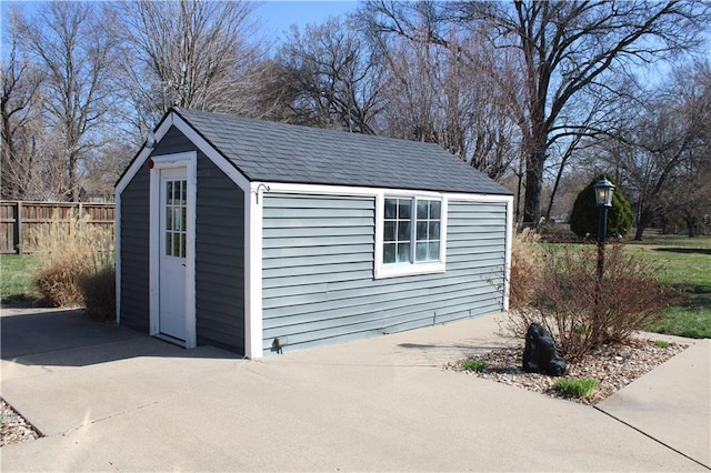 view of outdoor structure with an outbuilding and fence