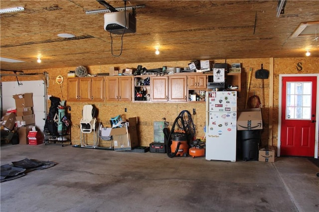 garage with a garage door opener and freestanding refrigerator