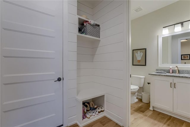 full bath featuring visible vents, toilet, wood finished floors, a shower, and vanity