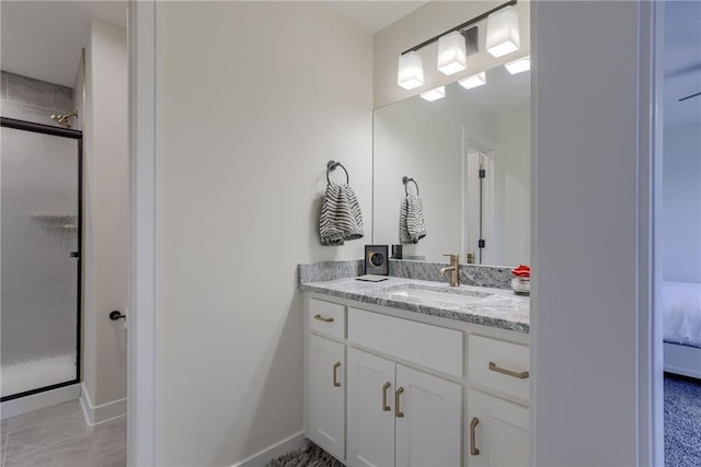 bathroom featuring vanity, a shower stall, baseboards, and connected bathroom