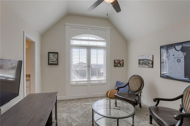 living area featuring carpet flooring, baseboards, ceiling fan, and vaulted ceiling