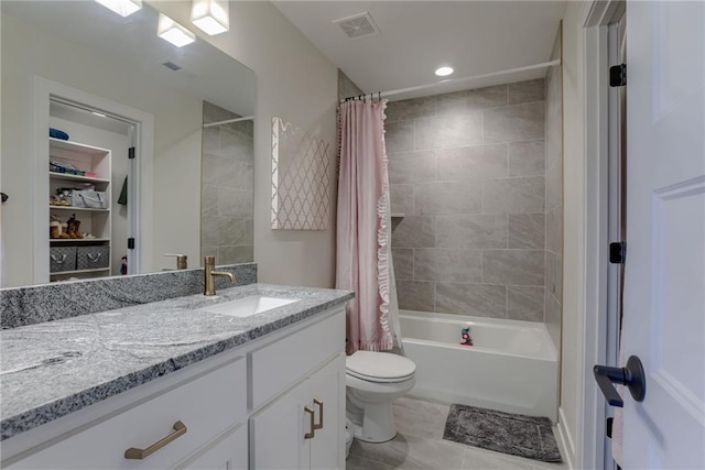 bathroom with vanity, visible vents, shower / bath combo with shower curtain, tile patterned floors, and toilet