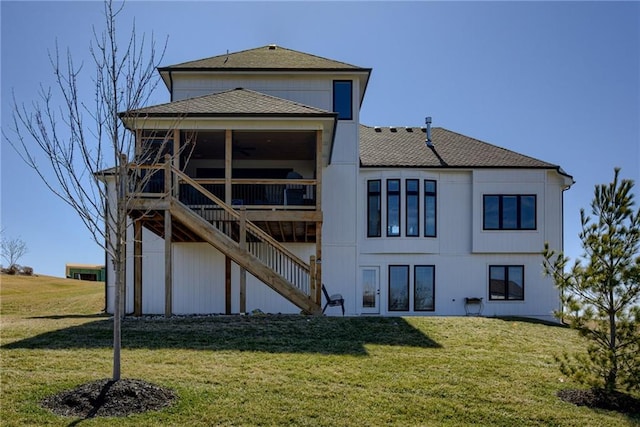 back of property featuring stairway, a lawn, and a shingled roof