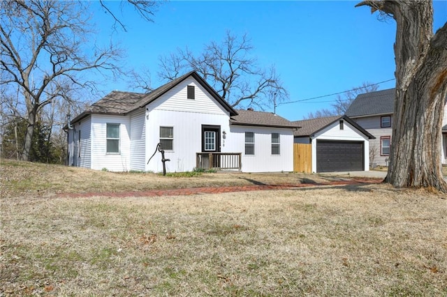 view of front facade featuring a front lawn, a garage, and an outdoor structure