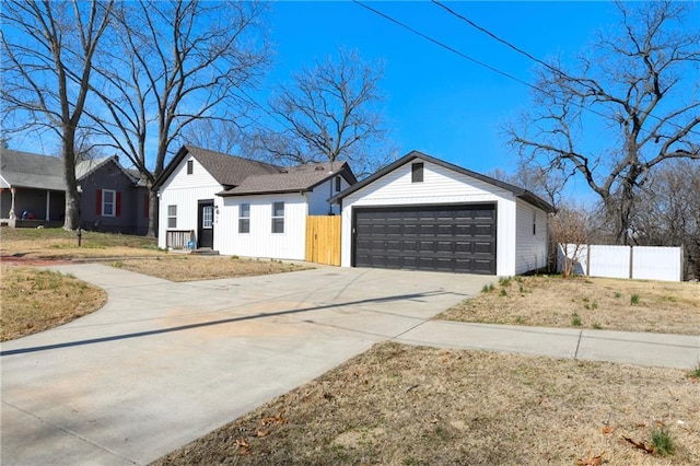 view of front of home with an outbuilding, a garage, and fence