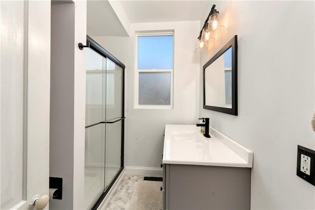 bathroom with vanity, a shower stall, and baseboards