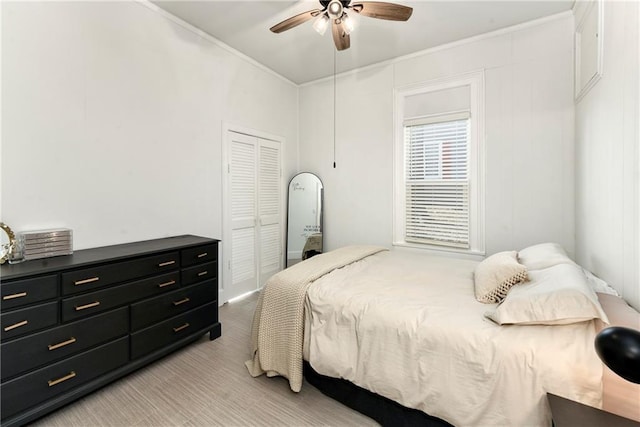 bedroom featuring a closet, a ceiling fan, and crown molding