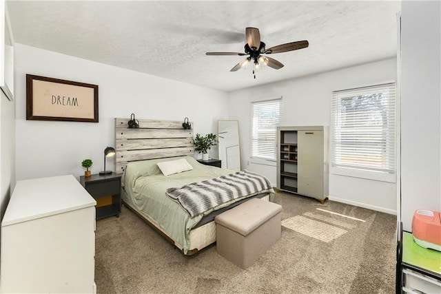 carpeted bedroom featuring ceiling fan, a textured ceiling, and baseboards