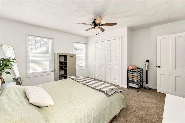 carpeted bedroom with a closet, a ceiling fan, and baseboards