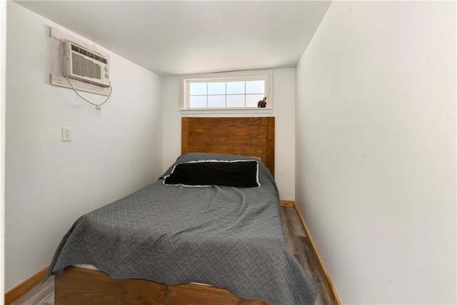 bedroom with baseboards and a wall unit AC