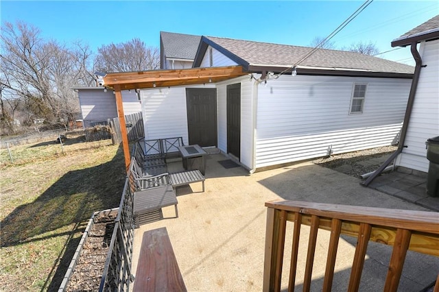 back of property featuring a patio, fence, and roof with shingles