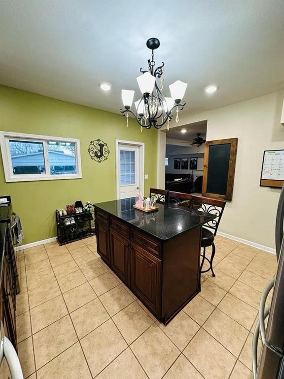 kitchen with light tile patterned flooring, an inviting chandelier, pendant lighting, a kitchen island, and recessed lighting