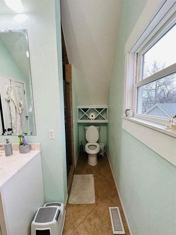 full bathroom featuring toilet, a stall shower, visible vents, tile patterned flooring, and vanity