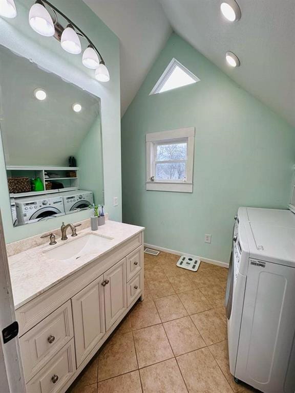 bathroom featuring tile patterned floors, washing machine and dryer, baseboards, lofted ceiling, and vanity