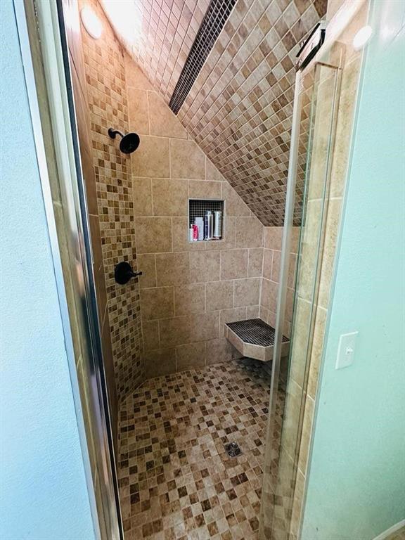 full bath with lofted ceiling and a stall shower