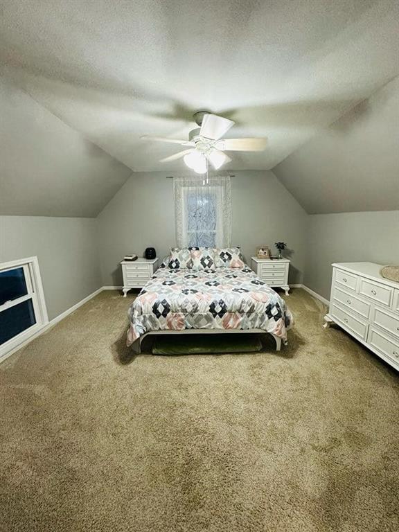 bedroom with lofted ceiling, carpet flooring, and baseboards
