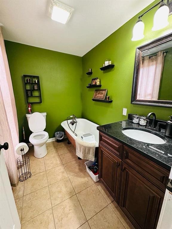 full bathroom with toilet, vanity, tile patterned flooring, and a bathtub
