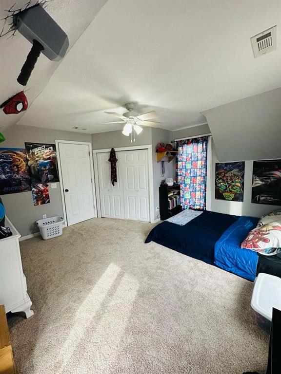 bedroom featuring a ceiling fan, visible vents, and carpet flooring