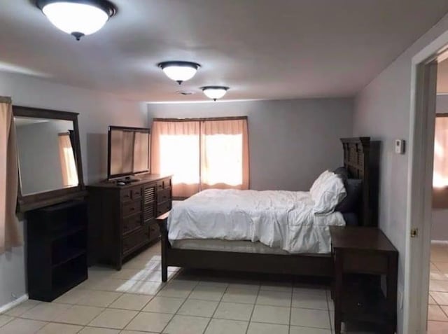 bedroom featuring baseboards and light tile patterned floors