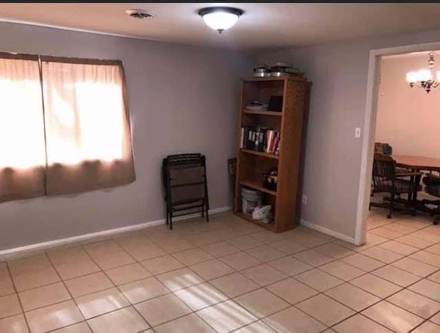 unfurnished room with light tile patterned flooring, visible vents, and baseboards