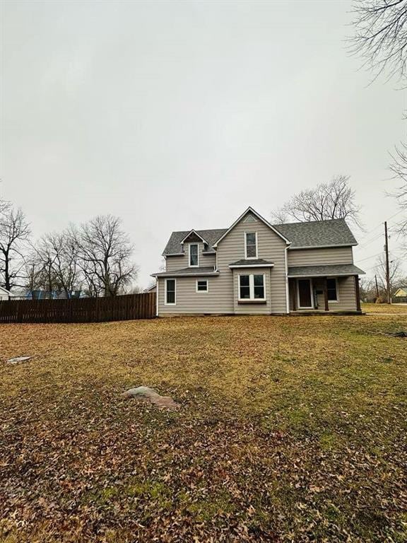 back of house with fence and a yard