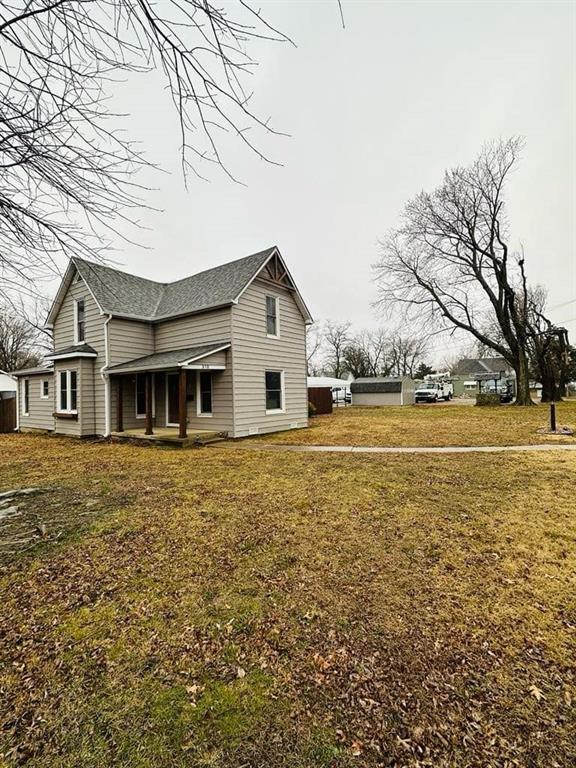 view of side of home featuring a lawn and roof with shingles
