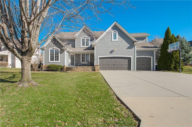 view of front of home with stucco siding, a front yard, a garage, and driveway