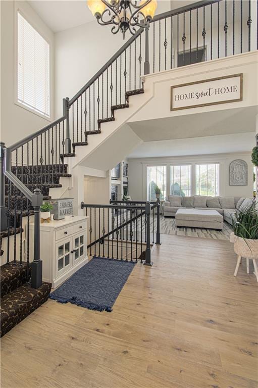 interior space featuring a chandelier, stairway, a high ceiling, and wood finished floors