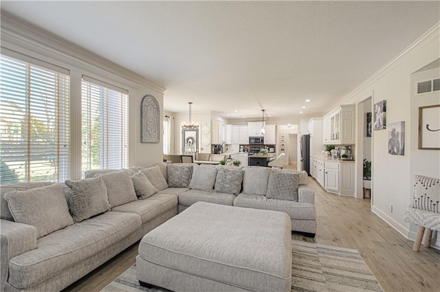 living area with visible vents, light wood-style flooring, ornamental molding, recessed lighting, and baseboards