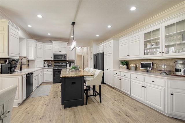 kitchen with black gas range, stainless steel microwave, dishwashing machine, and white cabinets