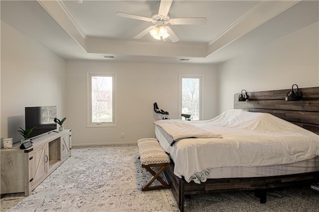 bedroom featuring baseboards, a raised ceiling, ceiling fan, and crown molding