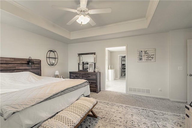 bedroom featuring a tray ceiling, visible vents, carpet floors, and ornamental molding