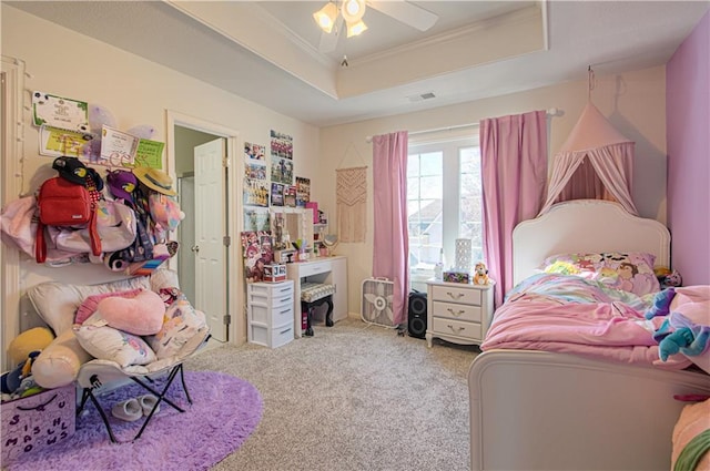 bedroom with visible vents, crown molding, ceiling fan, carpet, and a raised ceiling