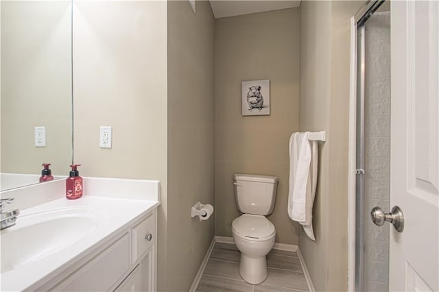 bathroom featuring baseboards, toilet, and vanity