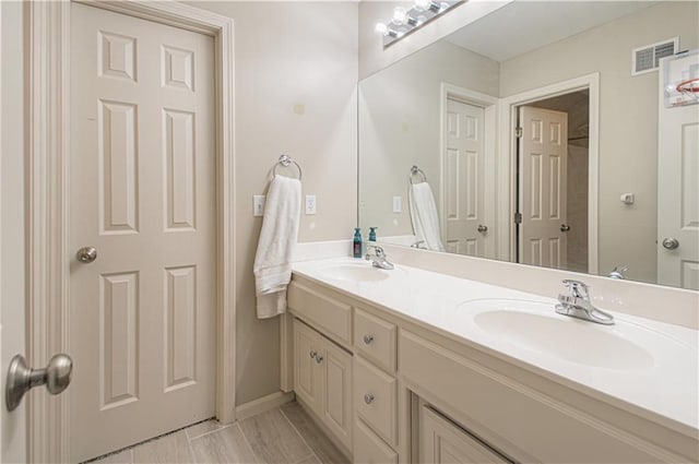 full bathroom with double vanity, visible vents, and a sink